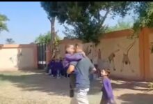 معلم يحمل طفلا