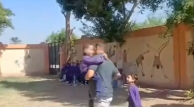 معلم يحمل طفلا