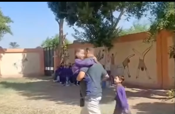 معلم يحمل طفلا